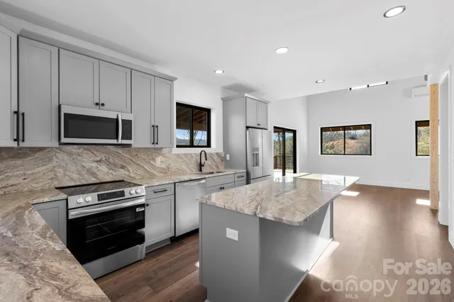 a kitchen with stainless steel appliances granite countertop a sink stove and refrigerator