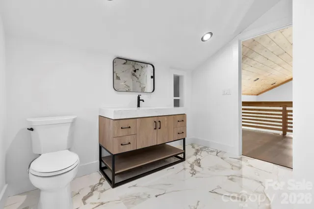 a bathroom with a sink mirror and toilet