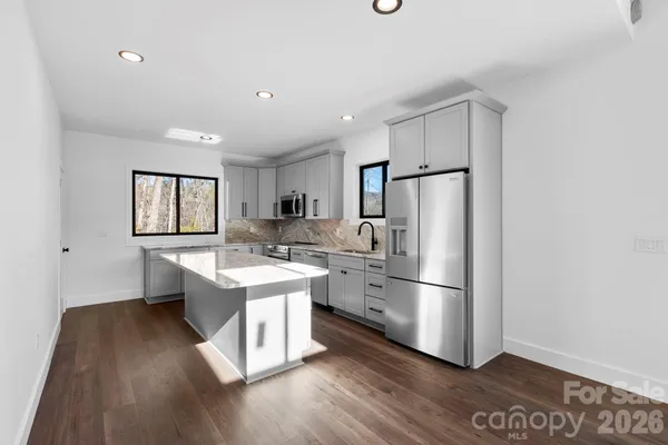 a kitchen with stainless steel appliances a refrigerator and a stove top oven