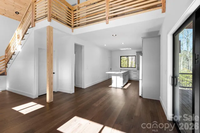 a view of a hallway with wooden floor and furniture