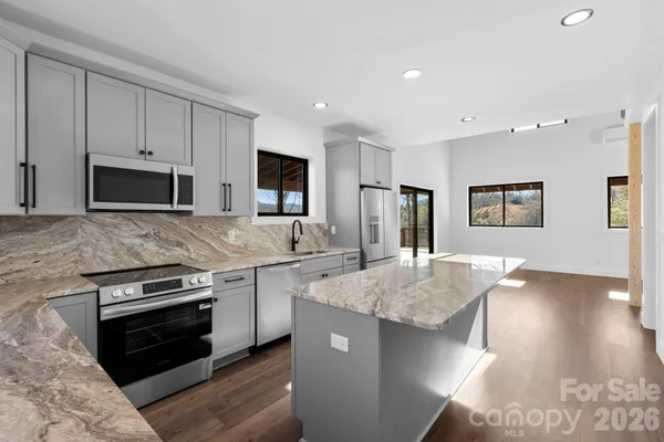 a kitchen with stainless steel appliances granite countertop a sink stove and refrigerator