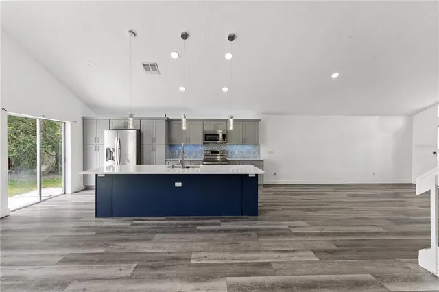 a view of kitchen with stainless steel appliances granite countertop cabinets and wooden floor