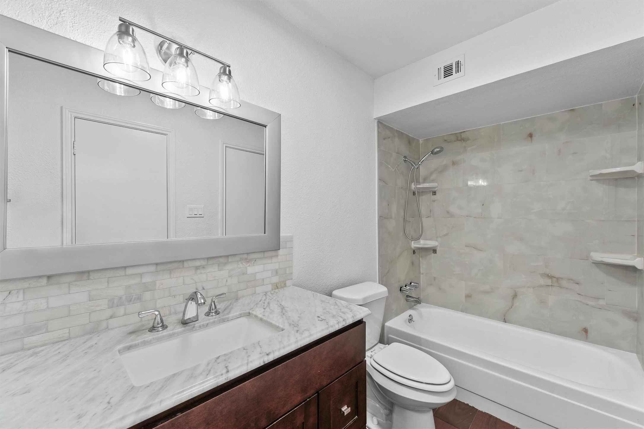 11550 Chimney Rock Road, Unit 536 Houston, TX 77035 - Photo 17 of 28 Primary bathroom - totally renovated with updated countertop, light fixture and mirror, toilet, and tub/shower combo