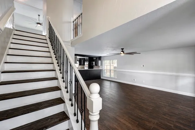 a bathroom with a granite countertop sink vanity mirror and toilet