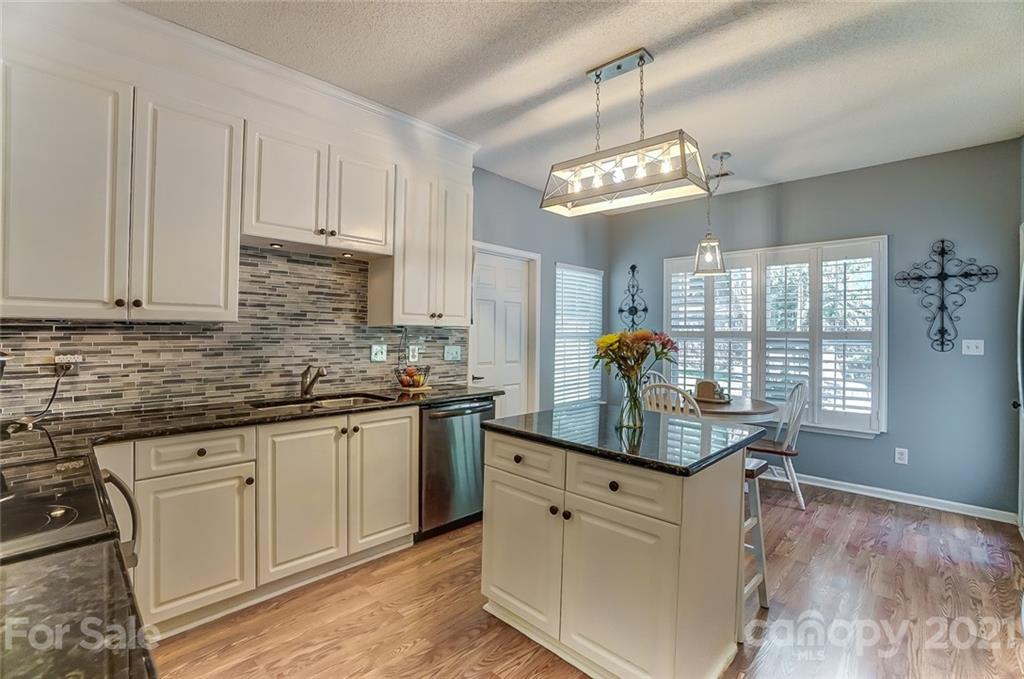 744 West Cheval Drive Fort Mill, SC 29708 - Photo 16 of 47 a kitchen with stainless steel appliances granite countertop a sink dishwasher and white cabinets with wooden floor