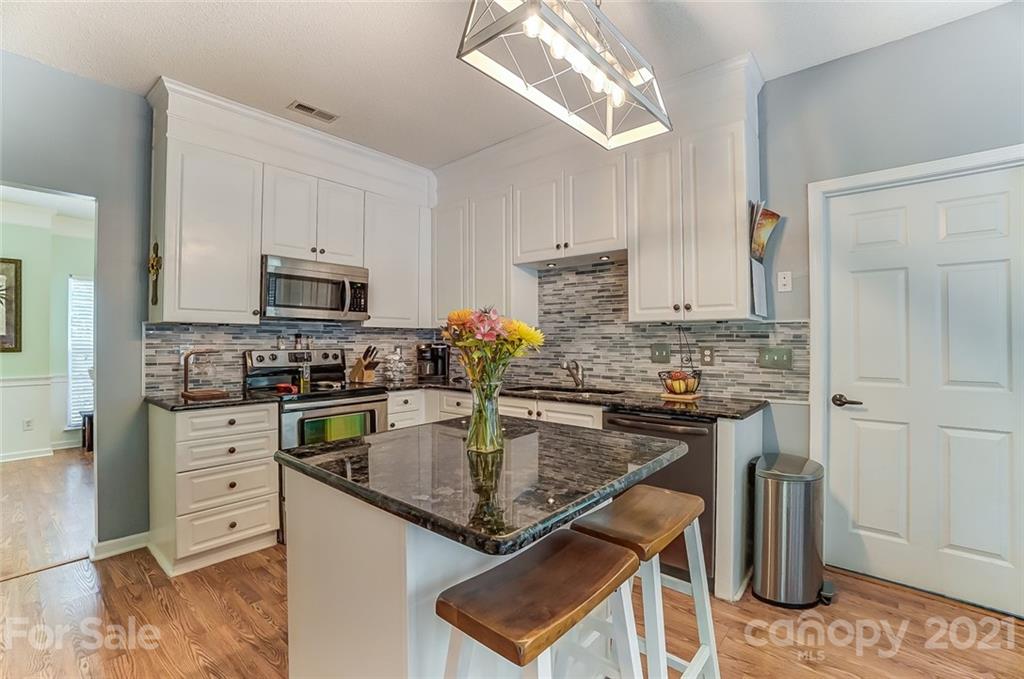 744 West Cheval Drive Fort Mill, SC 29708 - Photo 17 of 47 a kitchen with stainless steel appliances granite countertop a stove top oven a sink dishwasher and a refrigerator with wooden cabinets