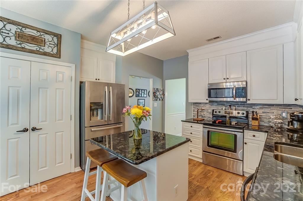 744 West Cheval Drive Fort Mill, SC 29708 - Photo 18 of 47 a kitchen with stainless steel appliances granite countertop a stove top oven a sink a counter space and cabinets