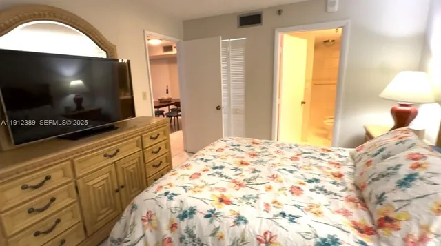 a bedroom with a bed and a flat screen tv
