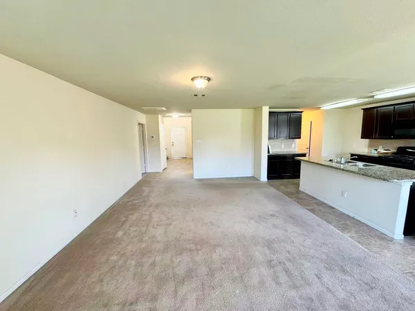 a view of empty room with furniture and flat screen tv