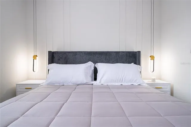 a bedroom with a bed and a painting on the wall