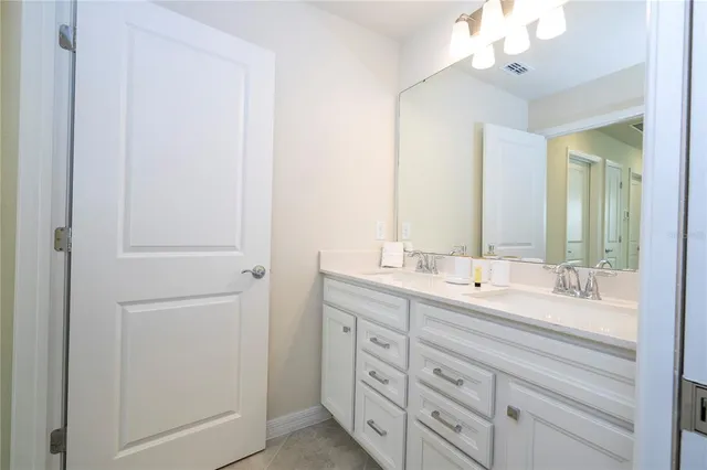 a spacious bedroom with a bed and a chandelier