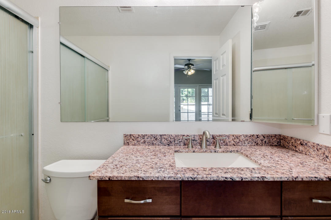 1222 West Baseline Road, Unit 112 Tempe, AZ 85283 - Photo 13 of 26 a bathroom with a granite countertop sink and a mirror
