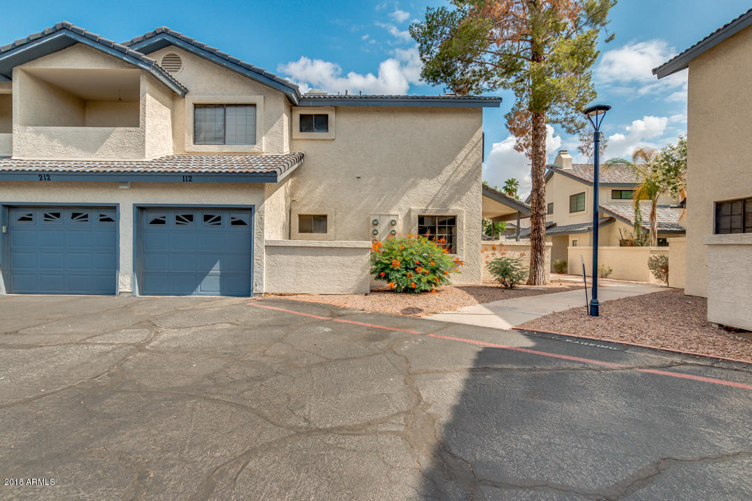 1222 West Baseline Road, Unit 112 Tempe, AZ 85283 - Photo 5 of 26 a front view of a house with a yard and garage