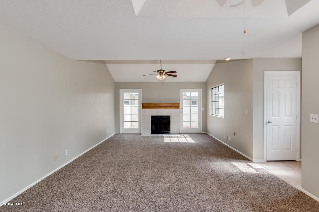 1222 West Baseline Road, Unit 112 Tempe, AZ 85283 - Photo 8 of 26 an empty room with a fireplace and windows