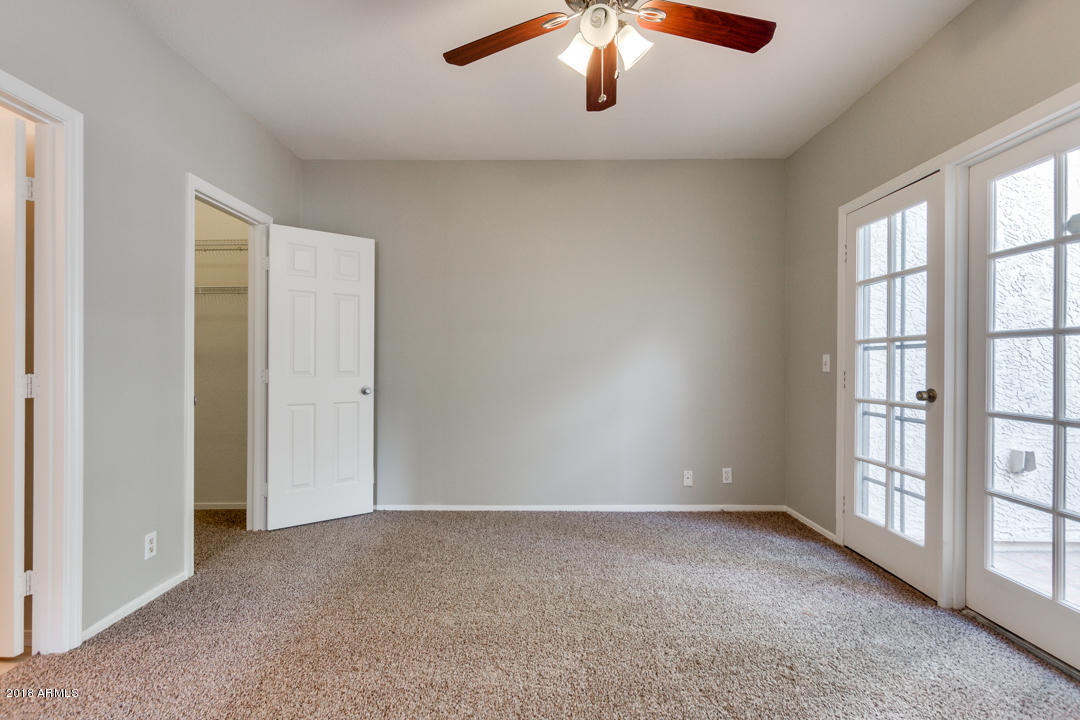 1222 West Baseline Road, Unit 112 Tempe, AZ 85283 - Photo 10 of 26 an empty room with chandelier fan and windows