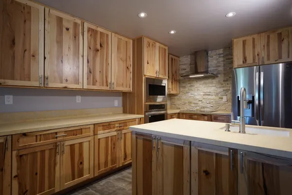 a kitchen with stainless steel appliances a sink dishwasher a refrigerator and cabinets with wooden floor