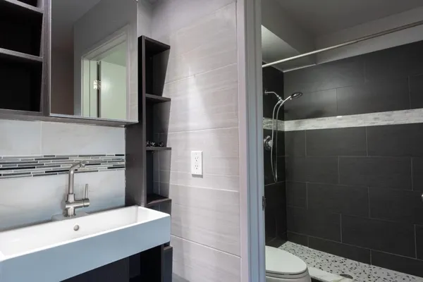 a bathroom with a sink a toilet and shower