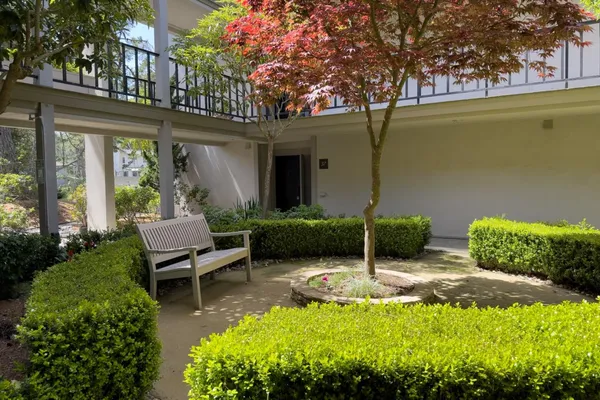 a view of a chair and table in backyard of a house