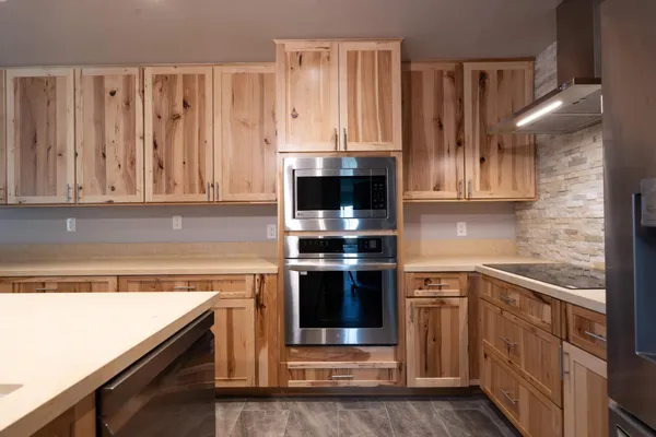 a kitchen with stainless steel appliances granite countertop a stove a sink and a microwave