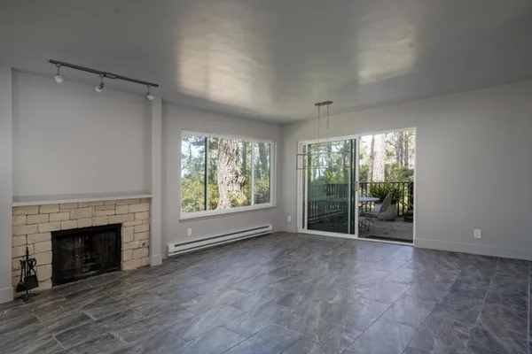 a view of an empty room with a fireplace and a window
