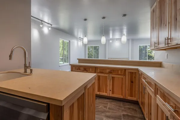 a kitchen with kitchen island a sink appliances and a counter top space