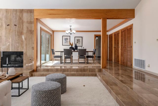 a dining room with wooden floor a chandelier a wooden table and chairs