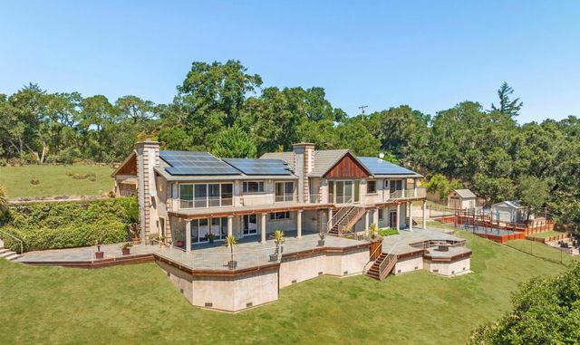 a view of a house with pool and chairs