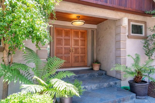 a front view of a house with plants