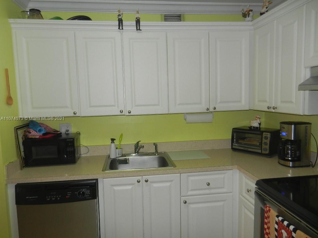 721 North Pine Island Road, Unit 112 Plantation, FL 33324 - Photo 11 of 27 a kitchen with stainless steel appliances granite countertop white cabinets and a refrigerator