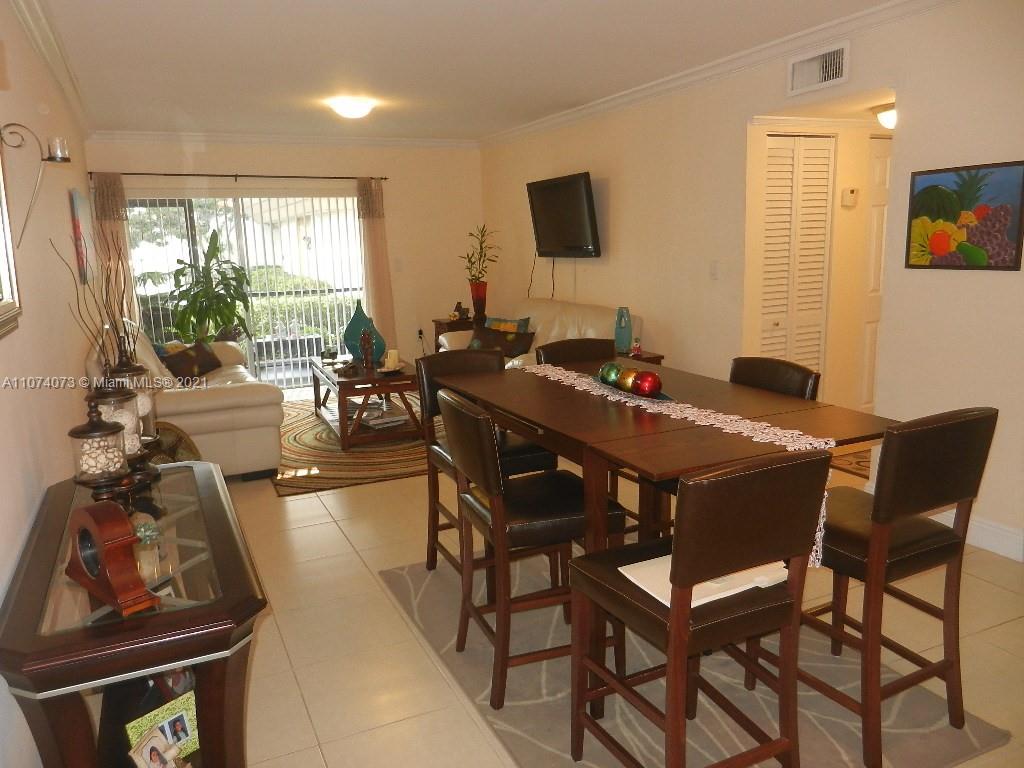 721 North Pine Island Road, Unit 112 Plantation, FL 33324 - Photo 4 of 27 a view of a dining room with furniture and a flat screen tv