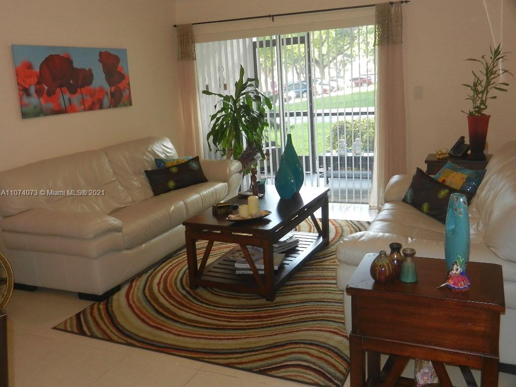 721 North Pine Island Road, Unit 112 Plantation, FL 33324 - Photo 7 of 27 a living room with furniture and a floor to ceiling window