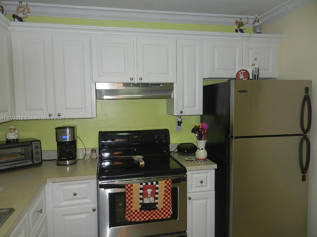 721 North Pine Island Road, Unit 112 Plantation, FL 33324 - Photo 9 of 27 a kitchen with refrigerator and cabinets