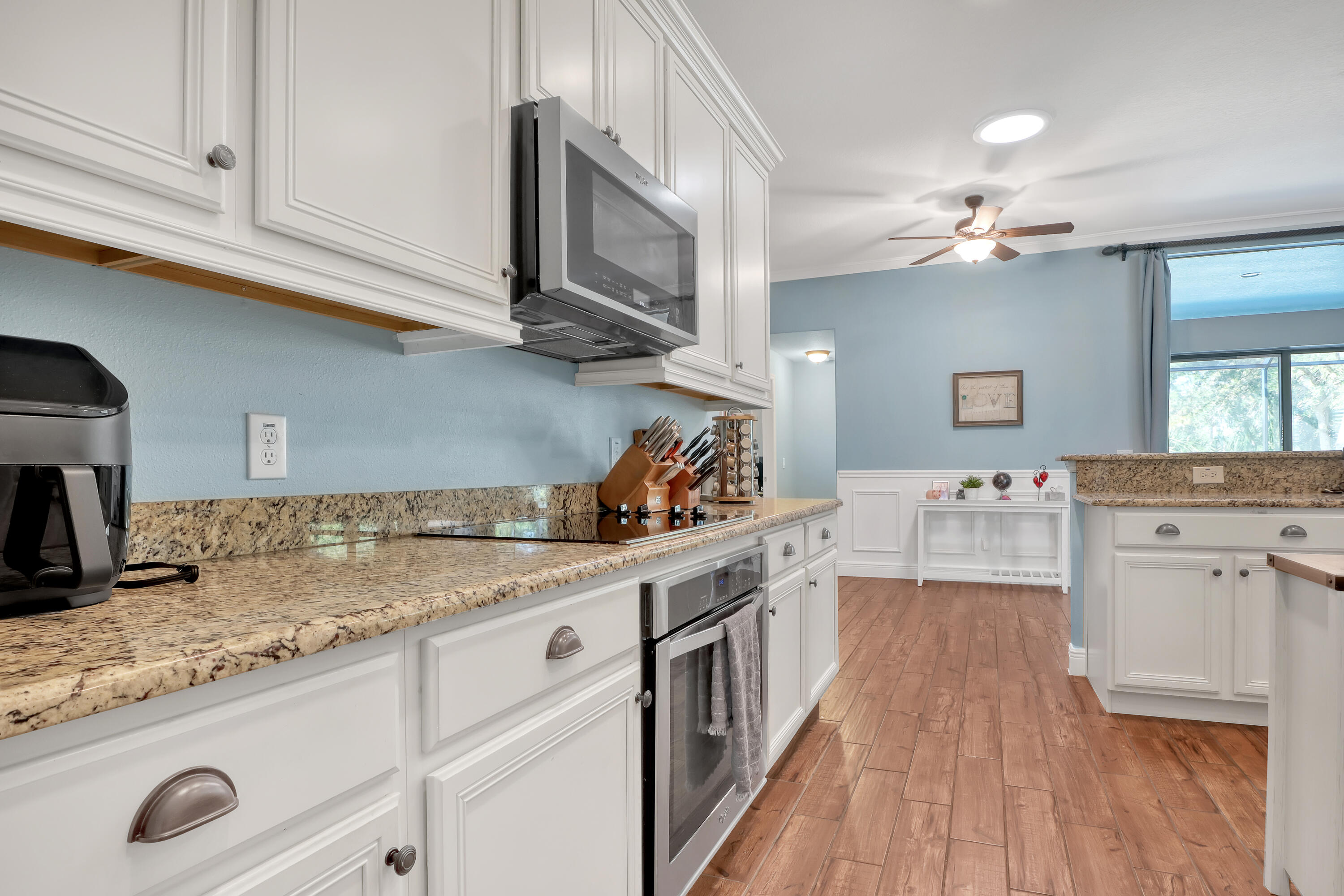 1358 Outrigger Circle Rockledge, FL 32955 - Photo 20 of 48 a kitchen with a sink dishwasher a stove and white cabinets with wooden floor