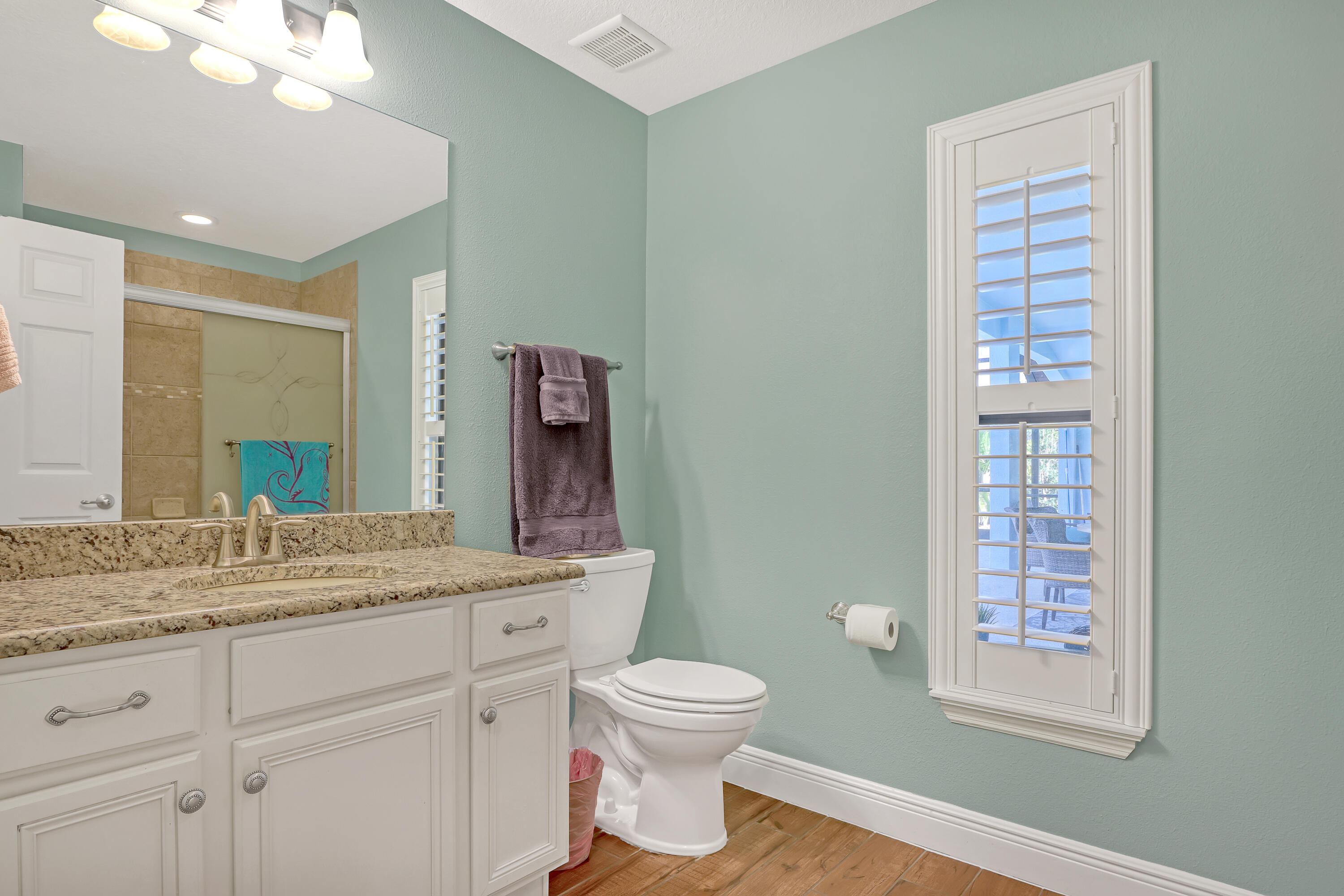 1358 Outrigger Circle Rockledge, FL 32955 - Photo 31 of 48 a bathroom with a granite countertop sink toilet a large mirror a vanity and window