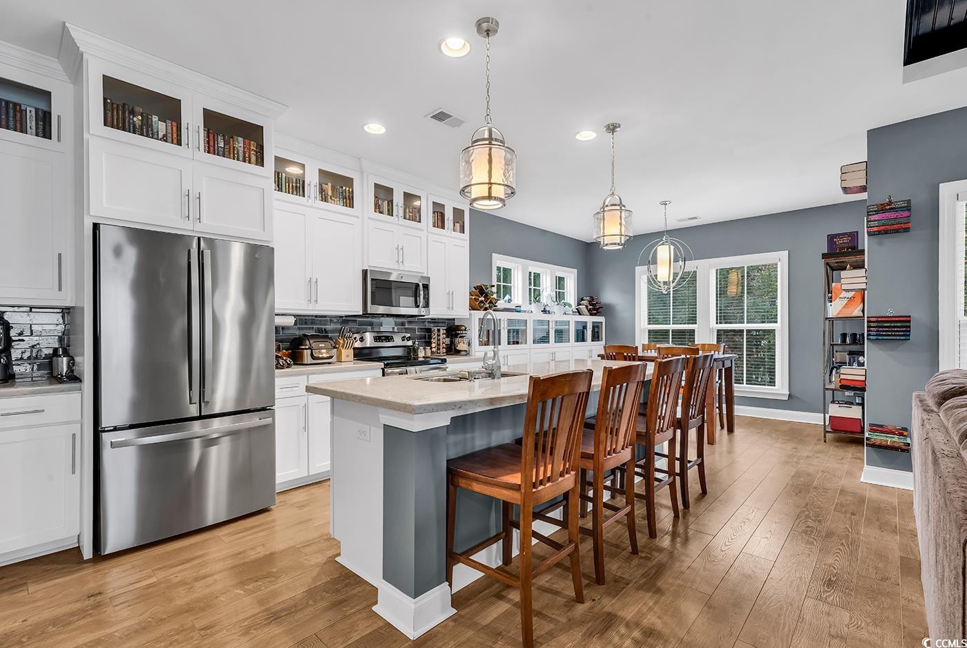 28 Pinnacle Drive Murrells Inlet, SC 29576 - Photo 4 of 40 Kitchen with hanging light fixtures, light hardwoo