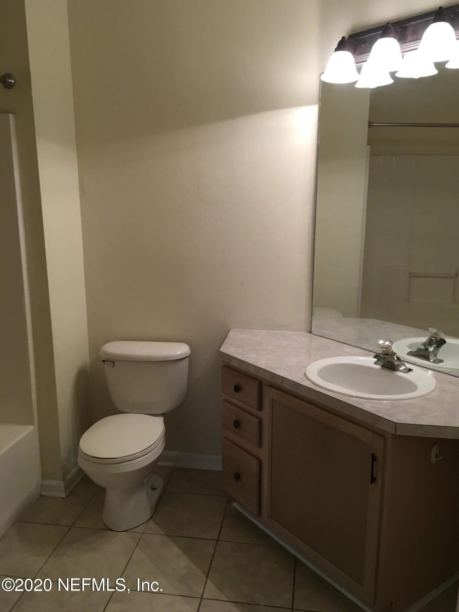 10550 Baymeadows Road, Unit 806 Jacksonville, FL 32256 - Photo 24 of 30 a bathroom with a toilet a sink and mirror