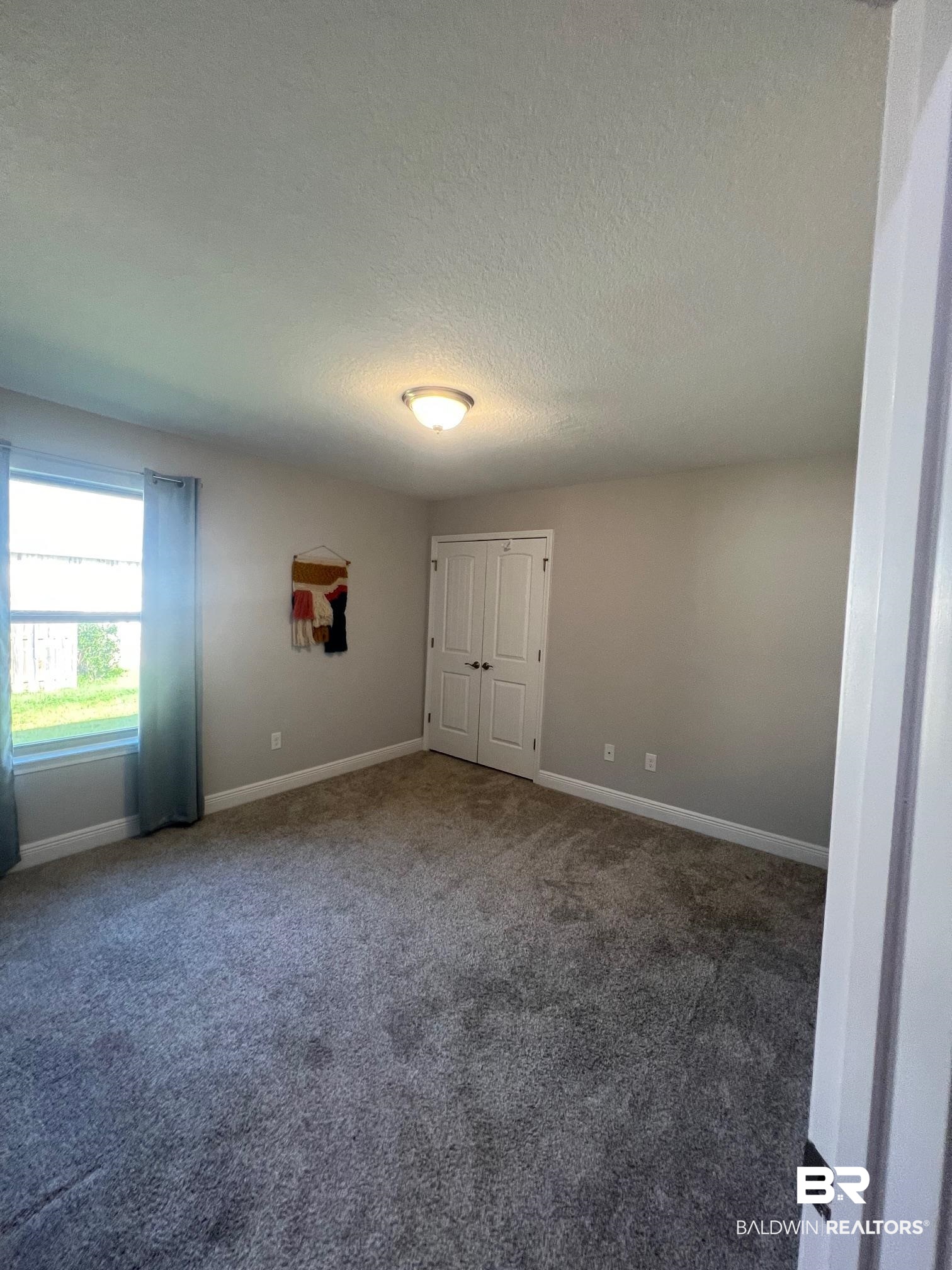 32915 Arbor Ridge Circle Lillian, AL 36549 - Photo 14 of 26 Unfurnished bedroom featuring carpet flooring and a textured ceiling