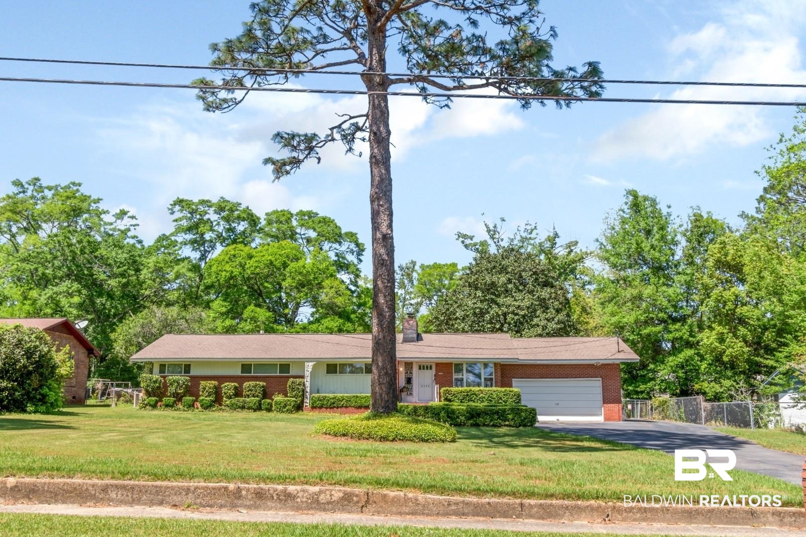 6300 Woodcrest Drive Mobile, AL 36608 - Photo 2 of 35 Single story home featuring an attached garage, aphalt driveway, brick siding, a front yard, and fence