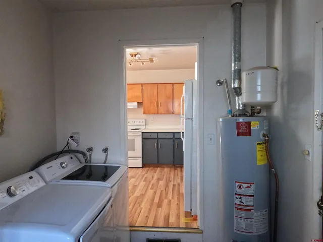 a room with a bed and a view of kitchen