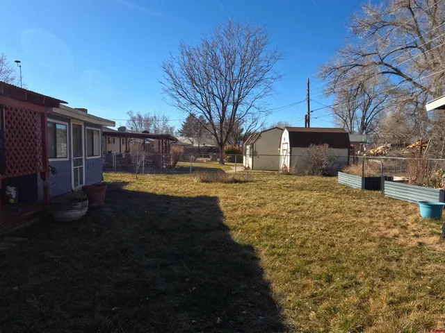 a view of a yard with wooden fence