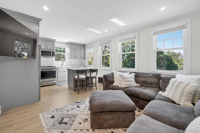 a living room with furniture a large window and a fireplace