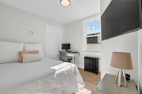 a bedroom with a bed flat screen tv and a lamp