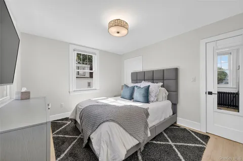 a bedroom with a bed and a flat tv screen on the dresser