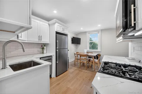 a kitchen with stainless steel appliances a stove a sink and a refrigerator