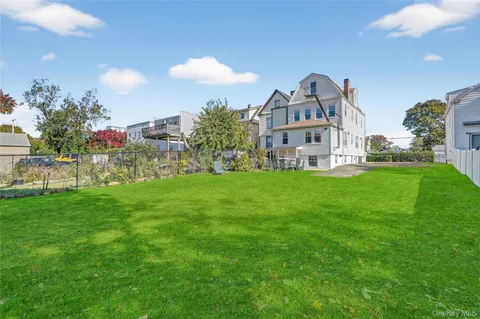 a view of a house with a big yard and a large tree