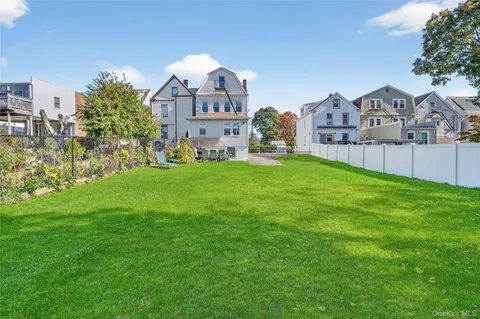 a view of a house with a big yard and large trees