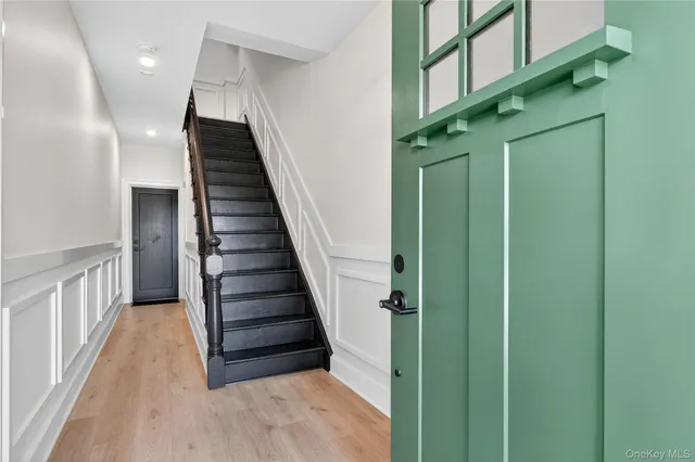 a view of entryway and hall with wooden floor