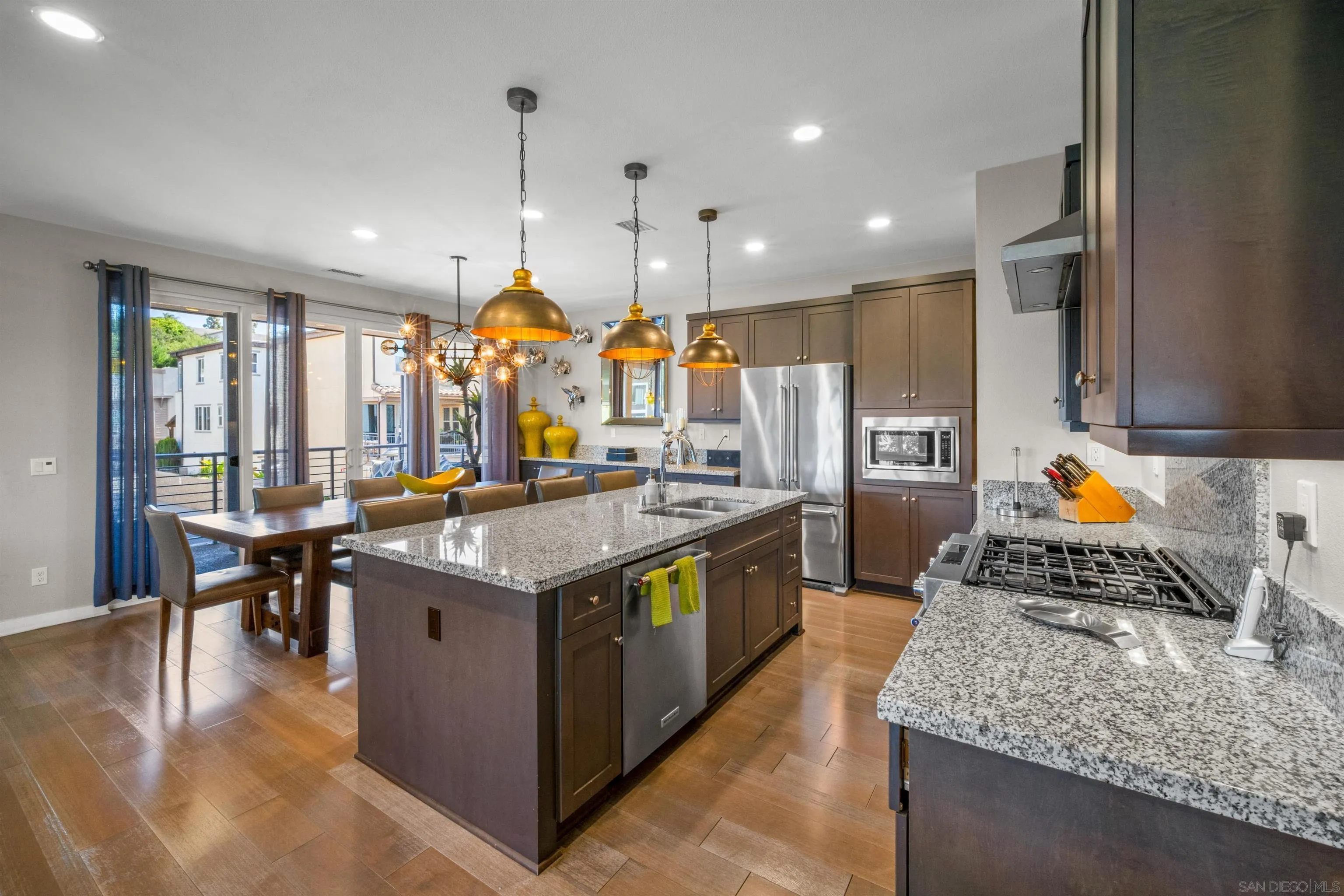 a kitchen with stainless steel appliances granite countertop wooden cabinets counter space and wooden floors