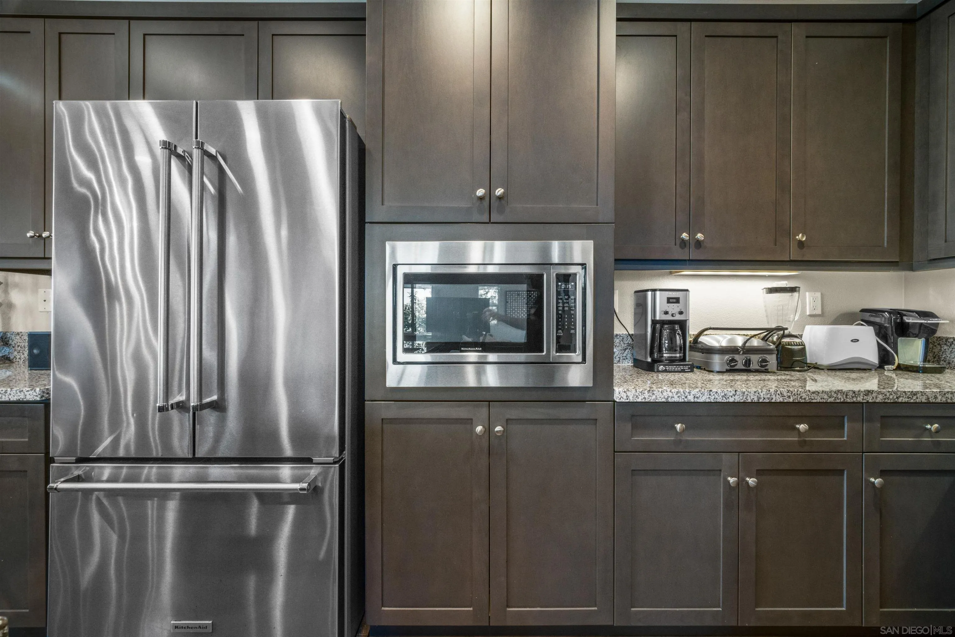 8329 Ridge Court San Diego, CA 92108 - Photo 18 of 39 a kitchen with granite countertop a refrigerator and cabinets