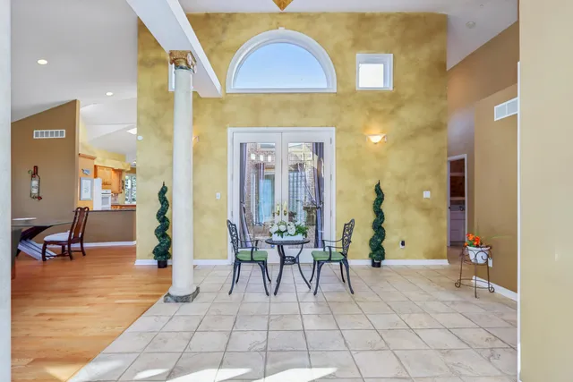a view of a hallway with dining area and glass windows